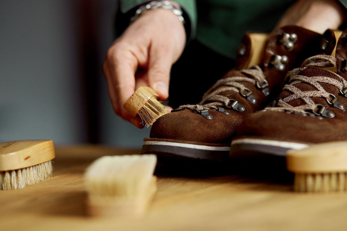 Veloursleder pflegen: Stiefel aus Velours werden mit einer Raulederbürste aus Messing gereinigt