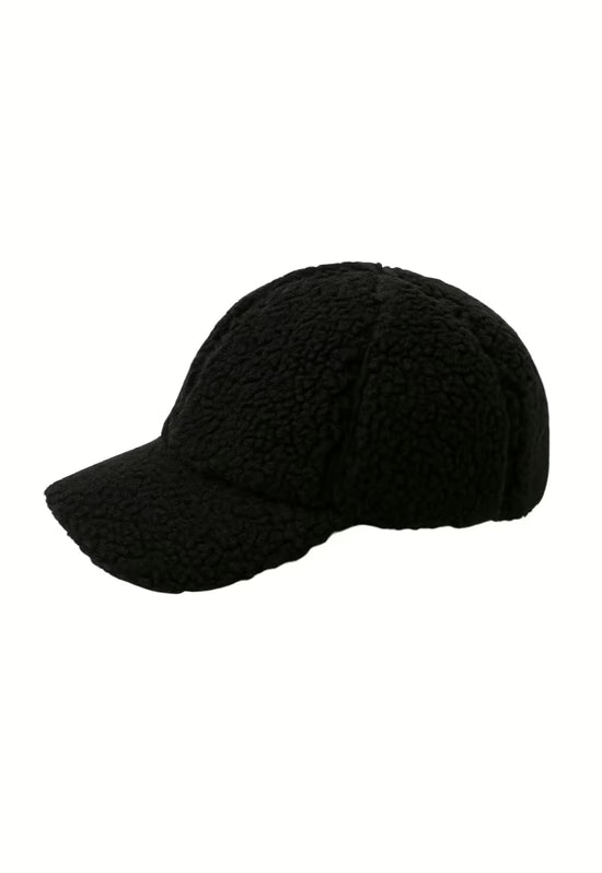 Black sheepskin cap, isolated in side view with a long peak.