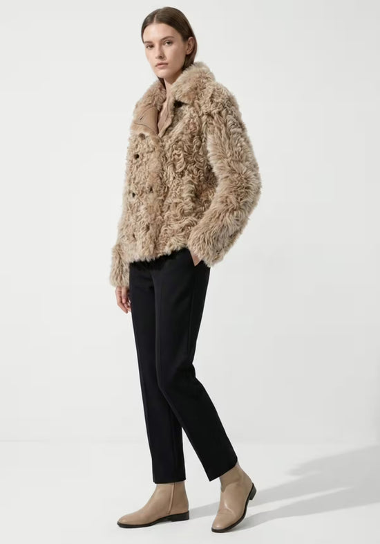 Women’s curly sheepskin jacket in cappuccino shown in side view with the fit visible.
