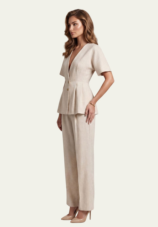 Women's linen set in beige shown from the side with a fitted blazer and wide trousers on a model.