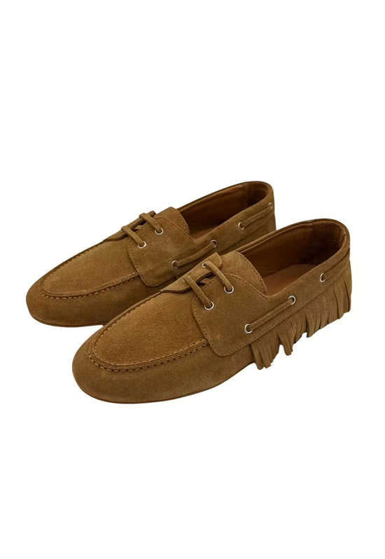 A pair of women’s moccasin shoes in camel leather with lacing and fringe trim.