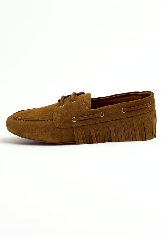 Women’s moccasin shoe in camel leather with fringe trim, shown from the side.