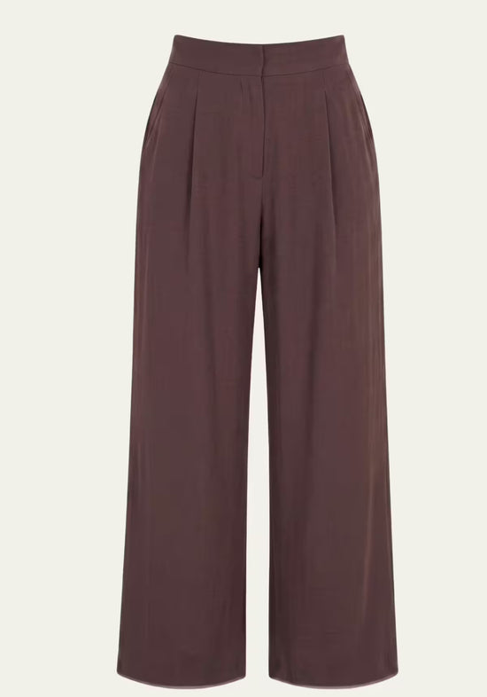 Brown women’s linen trousers shown from the front with wide legs and a high waist.