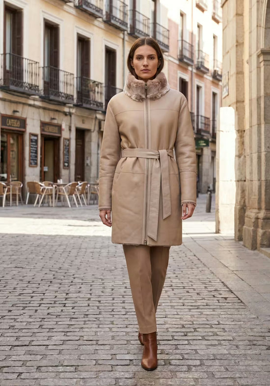 Beige sheepskin women's coat worn, front view with belt in the city
