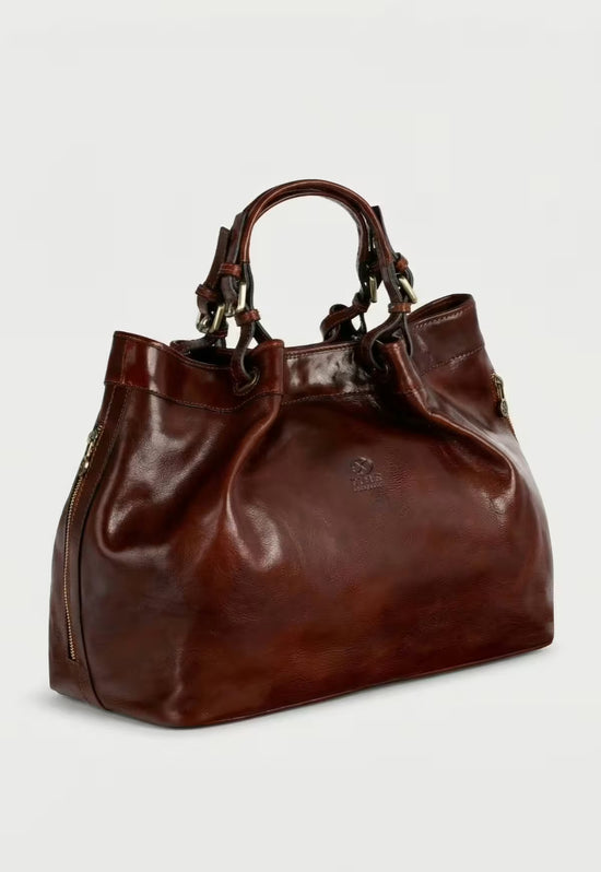 Brown leather handbag shown in side view with twin handles and a visible zip.