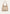 Cream-beige women's leather handbag shown freestanding from the front with a wide shoulder strap.