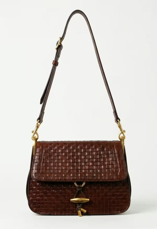 Women’s leather handbag in dark brown with flap, shown at an angle with a long strap.
