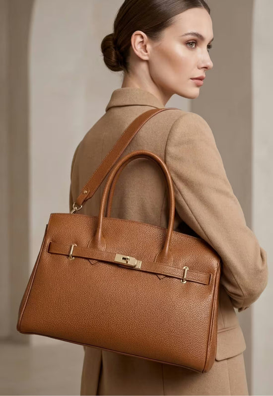 Camel-brown leather handbag for women shown worn over the shoulder.