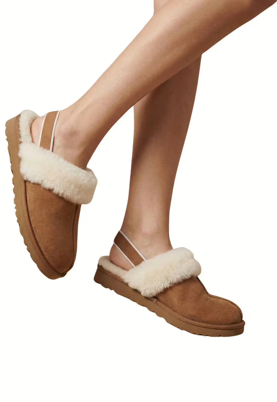 Brown women's sheepskin slippers worn on the feet, shown from the side and slightly angled.