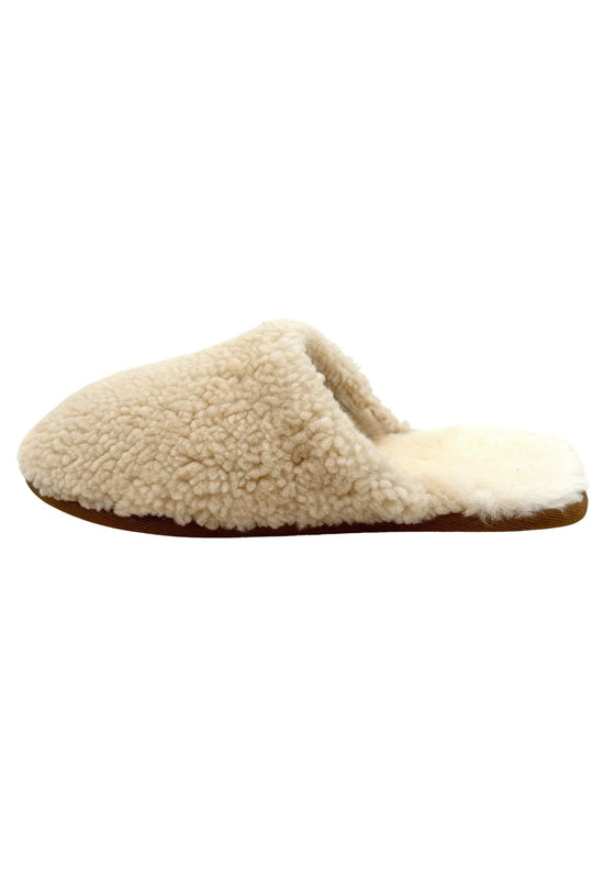 Women's sheepskin slippers in natural tone, shown from the side with a soft curly surface