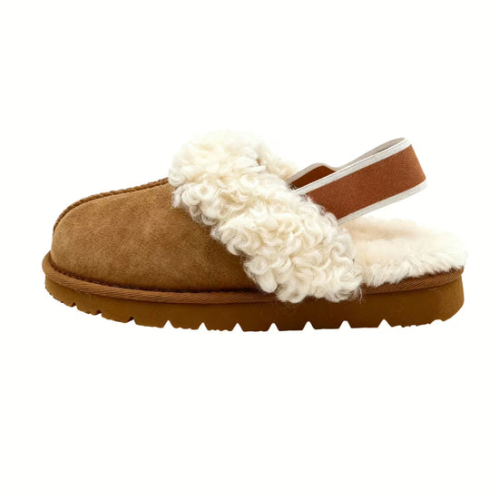 A brown women's sheepskin slipper in side view with visible heel strap and shearling trim.