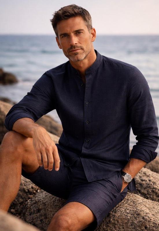Men’s linen shirt in dark blue worn by a man by the sea with an open collar