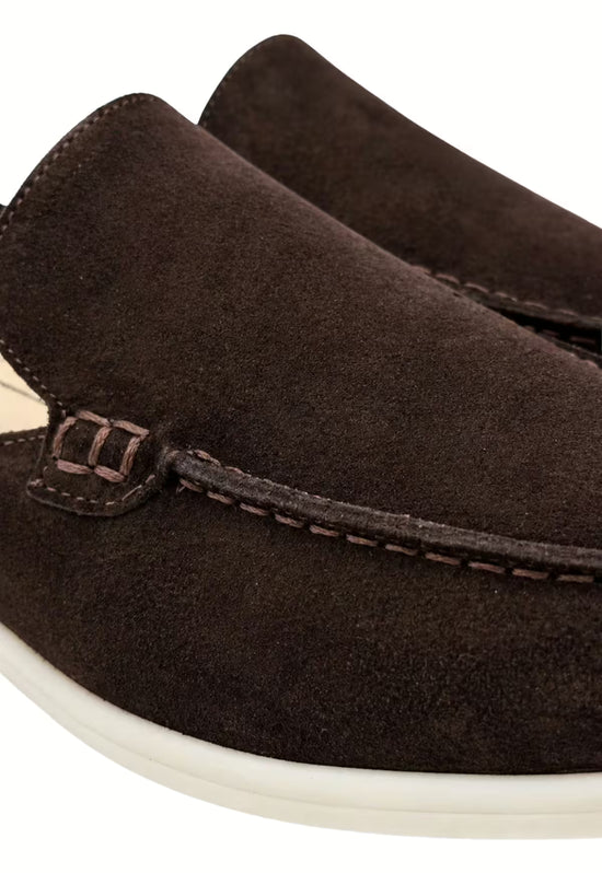 Detail view of a men's slipper in black calf suede with stitching and decorative strap.