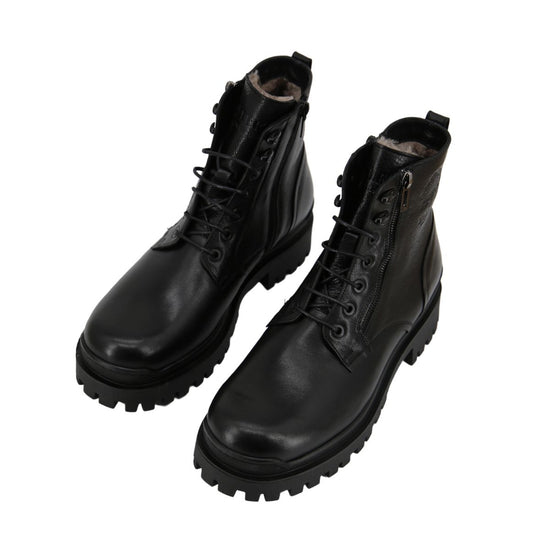 Black men's sheepskin shoes shown as a pair in an angled view with shearling trim and lug sole