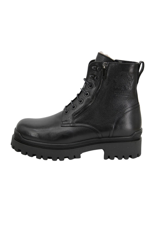 Black men's sheepskin shoe shown from the side with a sturdy lug sole and zip fastening