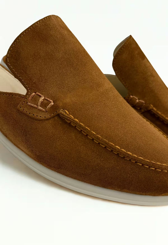 Close-up of a men's slip-on shoe in whisky brown leather, showing the seam and moccasin edge.