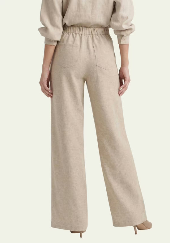 Beige women's linen trousers shown from the back with an elasticated waist and wide leg.