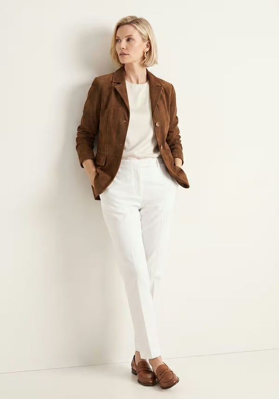 Women's jacket in cognac suede, shown on the model in a side full-body view with lapels and pockets.