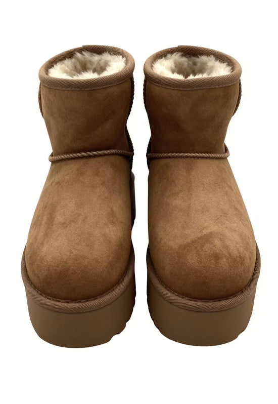 Brown sheepskin boots for women shown from the front with a short shearling cuff and platform sole.