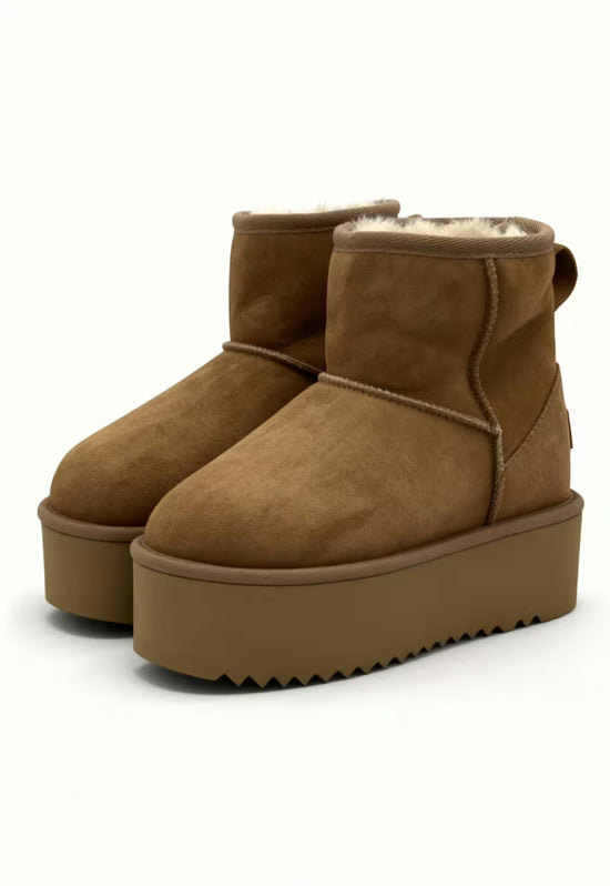 Pair of brown sheepskin ankle boots with visible shearling trim and a high platform sole.