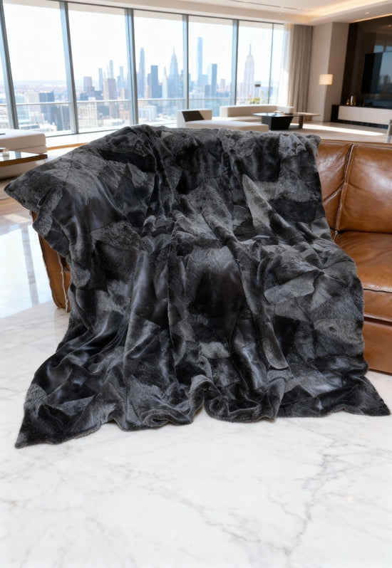 Large grey merino sheepskin throw spread across a brown sofa in the living room.