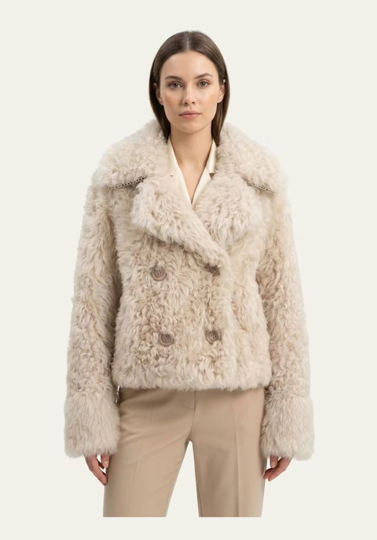 Curly sheepskin jacket for women in cream beige, worn by a model from the front with a wide collar and straight cut.