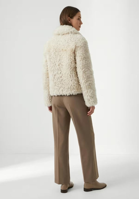 Cream curly sheepskin jacket for women worn from the back, with a straight hem and long sleeves