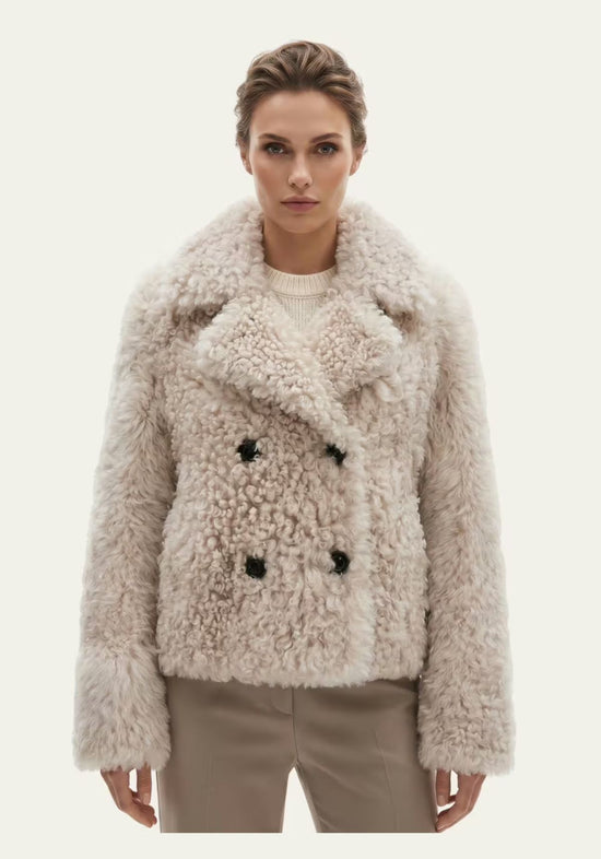 Women’s curly sheepskin jacket in cream beige, worn on a model from the front.