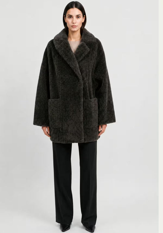Women’s sheepskin jacket in khaki on a full-length model, front view with a loose, straight shape.