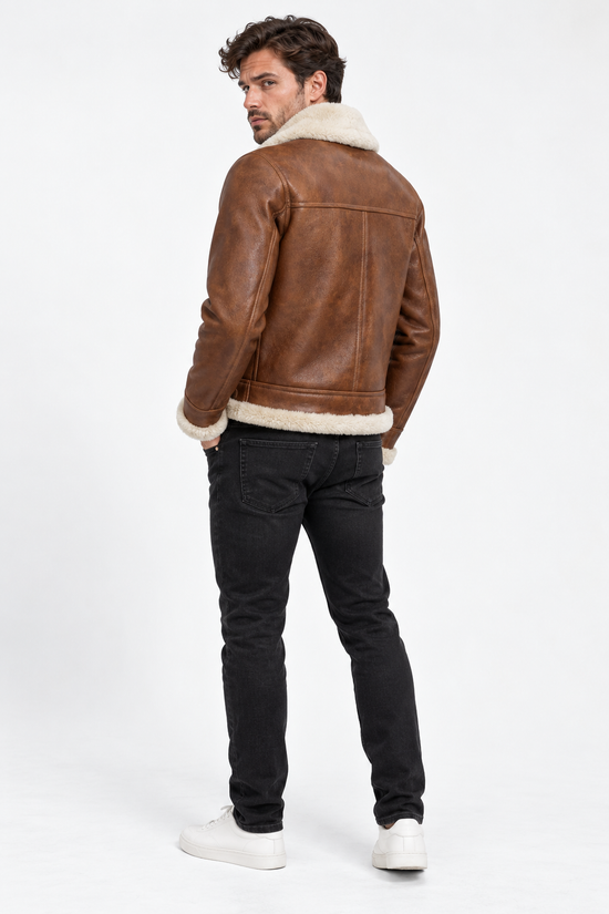Men's sheepskin jacket in chestnut and cream, seen from the back on the model with a wide shearling hem.