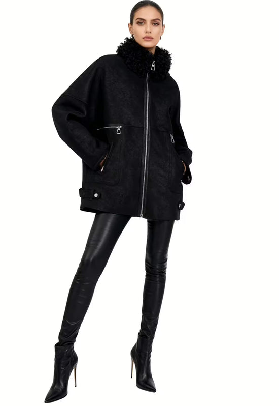 Black women's sheepskin jacket on a model in front view, with a curly collar, zip pockets and a slim silhouette.