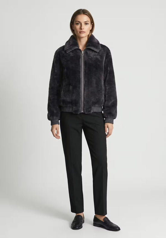 Women's shearling sheepskin jacket in anthracite, shown as a full-length look with dark trousers