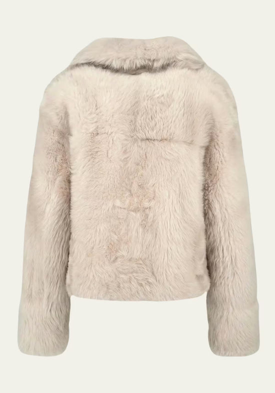 Rear view of the cream-beige sheepskin jacket, showing the back panel and collar.