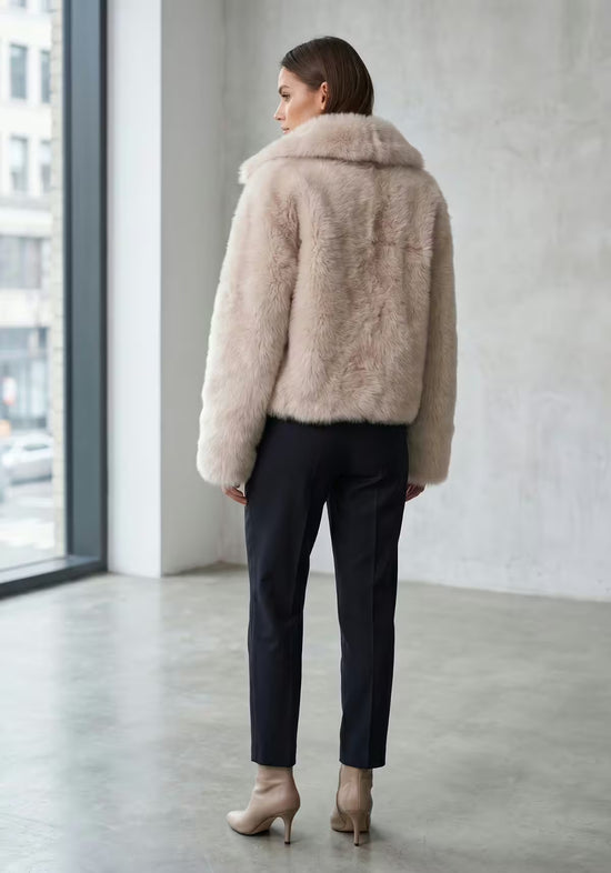 Rear view of the cream-beige sheepskin jacket with a short cut and wide collar.