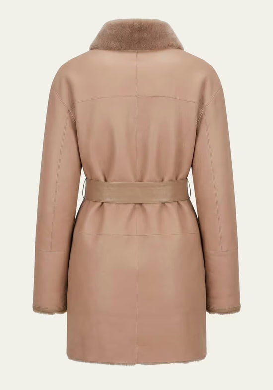 Back view of the beige women's sheepskin coat with stand-up collar, waist belt and straight hem.