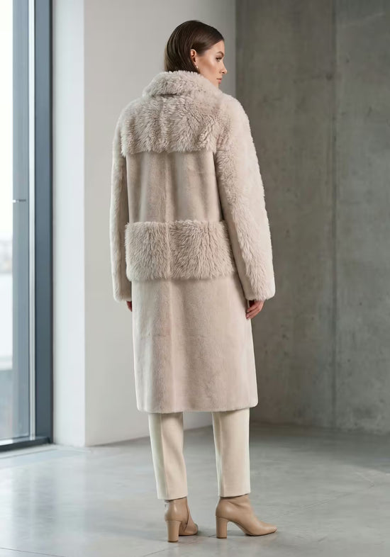 Rear view of the beige women’s sheepskin coat with a large shearling section at the collar and back.