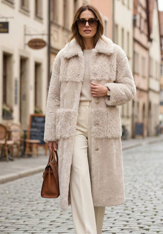 Beige sheepskin coat for women in an outdoor wear shot on a street, with sunglasses and handbag.