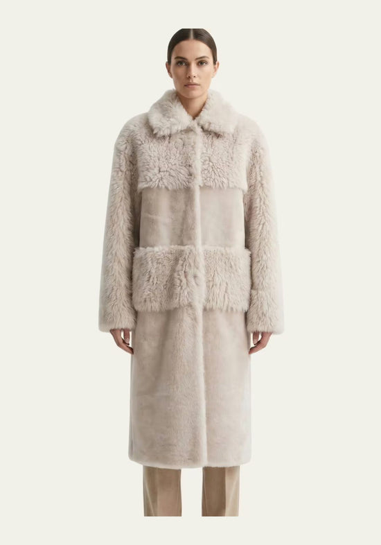 Beige sheepskin coat for women shown on model from the front with a straight cut and collar.