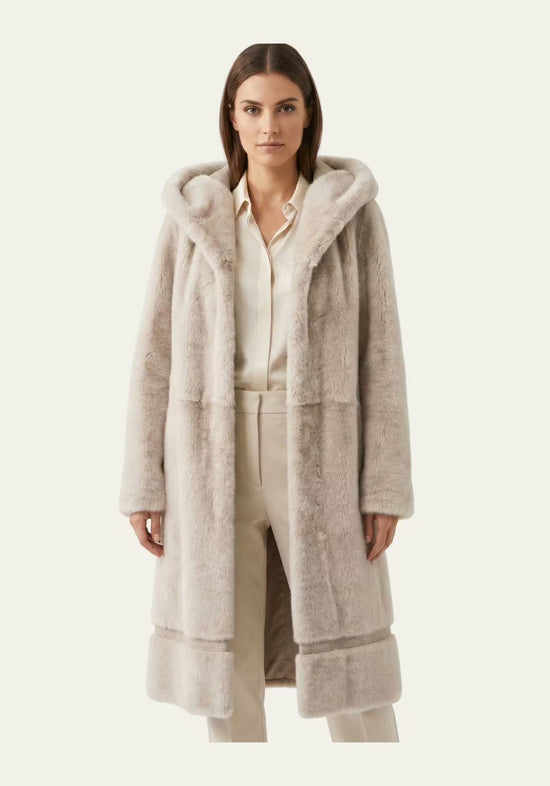 Women’s sheepskin coat in cream-beige with hood, worn frontally on a model.