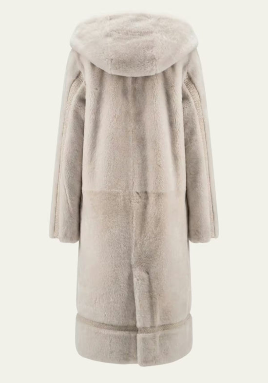 Back view of the women’s sheepskin coat in cream-beige with hood, cut out.