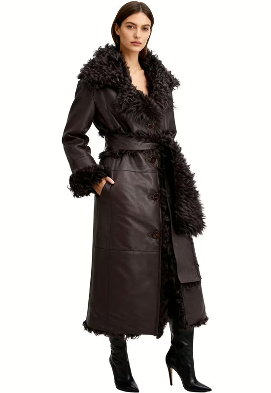 Women's sheepskin coat in dark brown worn open on a model, with a belt and long fur trim.