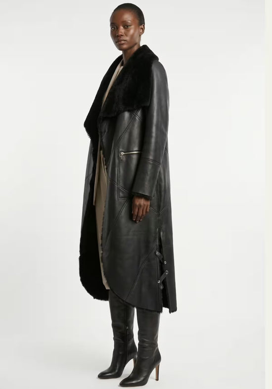 Black women’s sheepskin coat in side view with leather sleeves and zip pocket.