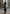 Black women’s sheepskin coat shown outdoors in an urban view with a long cut and boots.