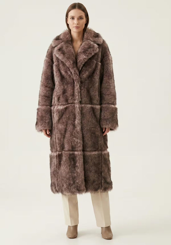 Women’s sheepskin coat in taupe on a model from the front, falling smoothly with a wide shawl collar.