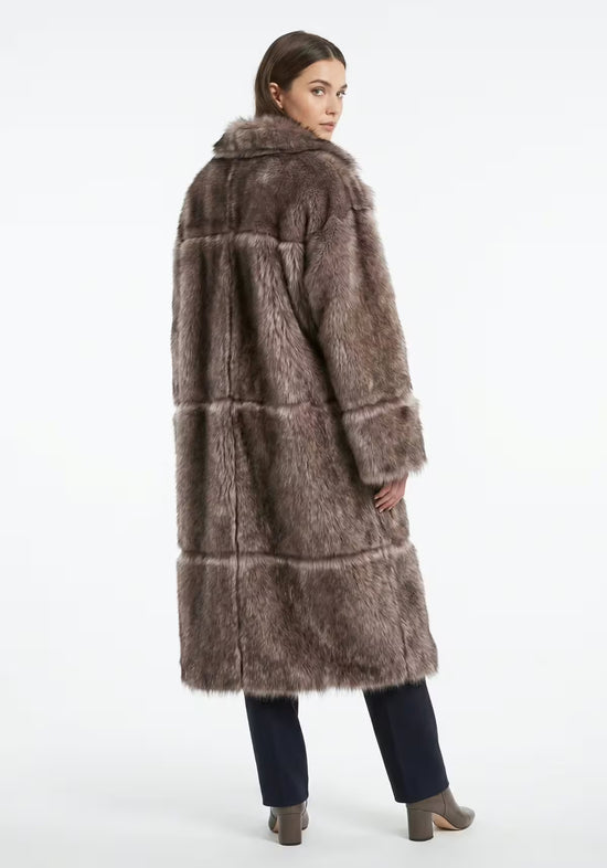 Women’s sheepskin coat in taupe on a model from the back, with a long back and soft fur pile.