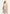 Beige women’s sheepskin coat worn open, with wide lapels and soft sheepskin trim.