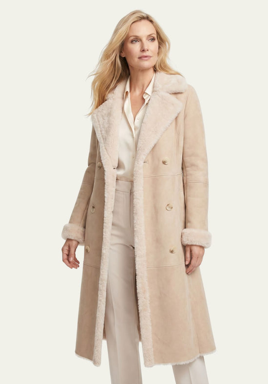 Beige women’s sheepskin coat worn open, with wide lapels and soft sheepskin trim.