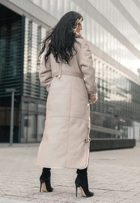 Women's sheepskin coat in beige from the back, with belt, smooth back panel and long hem.