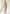Women’s sheepskin coat made from curly sheepskin in cream-beige, front view in a bright studio with a soft drape.