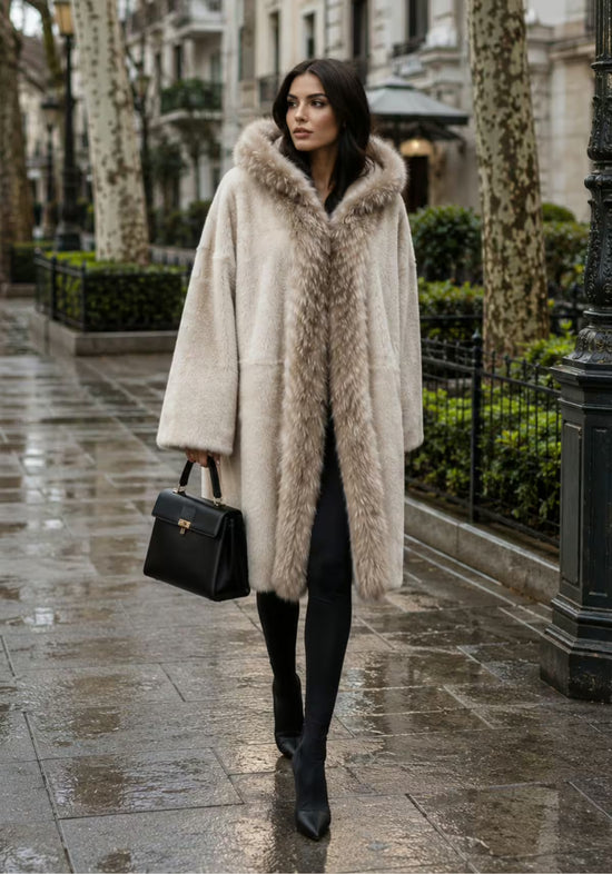 Cream women’s sheepskin coat worn outdoors on a wet street.
